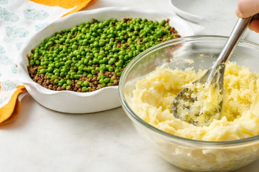 Step-by-step preparation of shepherd’s pie in a white ceramic dish with beef, peas, and mashed potatoes